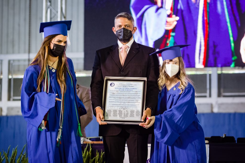 8. Eden Beraja y Natalie Jalfón entregan una placa al padrino de promoción Elleri Martinez graduandos